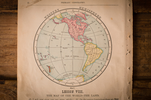 Color image of old color map of the Western Hemisphere, from the 1800's, sitting on wood background.