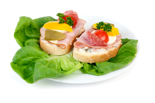 Two open sandwiches on lettuce. Ready to eat. Isolated on white background.