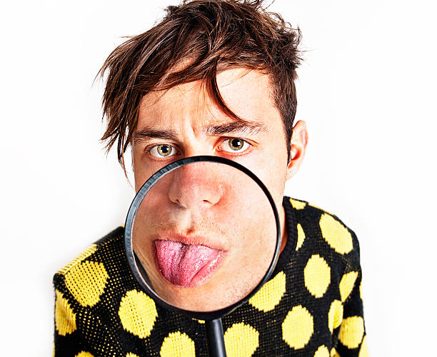 健康チェック: 内部の若い男性が虫眼鏡で舌革 - malingerer ストックフォトと画像