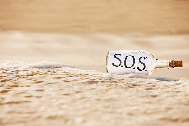 urgently 人のニーズにお応えいたします。sos メッセージのボトル - message in a bottle beached bottle desert island ストックフォトと画像