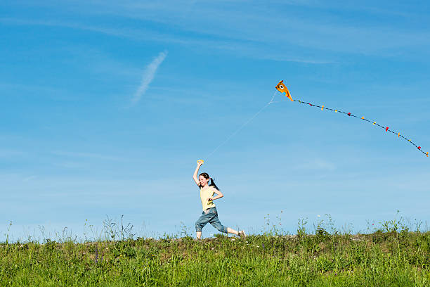 istock happy girl flying her kite 471414029