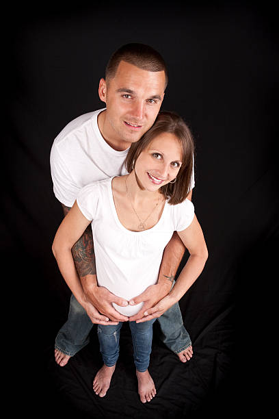 Husband kissing pregnant wife belly tenderly