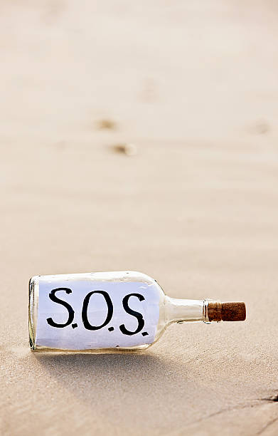 frantic sos послание в бутылке на необитаемый пляж - stranded message in a bottle island document стоковые фото и изображения