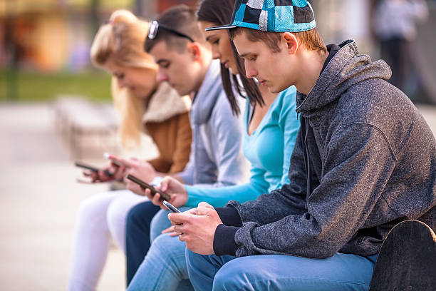 adolescentes el uso de teléfonos móviles - early teens teenager adult student people in a row fotografías e imágenes de stock