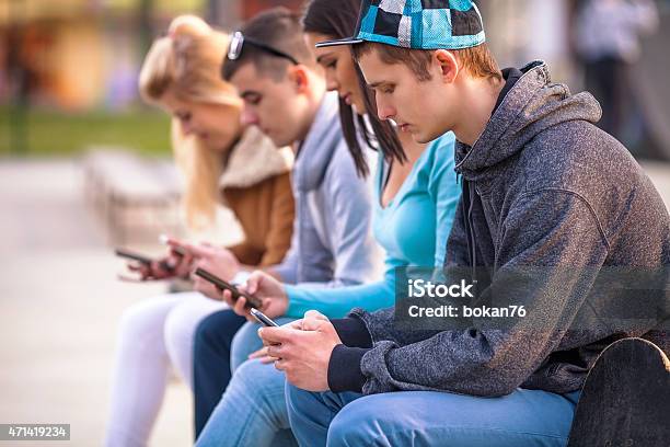 Teenagers Using Mobile Phones Stock Photo - Download Image Now - Teenager, Adolescence, Mobile Phone