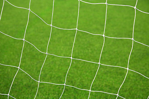 istock White soccer net with green grass background 471419257