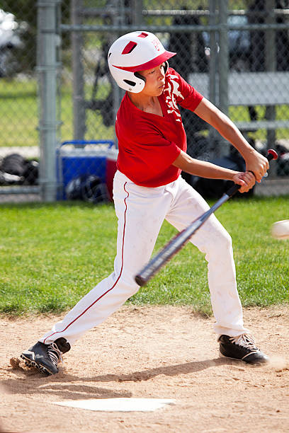 istock Young Male Baseball Player Hits Ball in Batter's Box 471419277