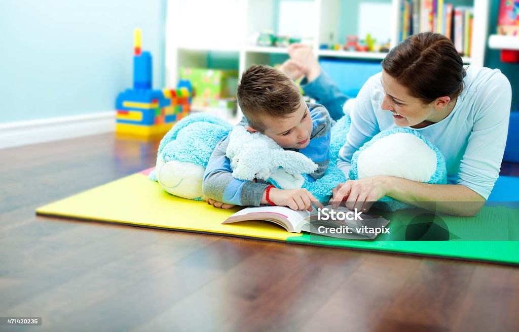 Madre e hijo leer un libro - Foto de stock de 30-39 años libre de derechos