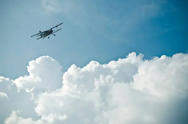 biplane between impressive cloud formation