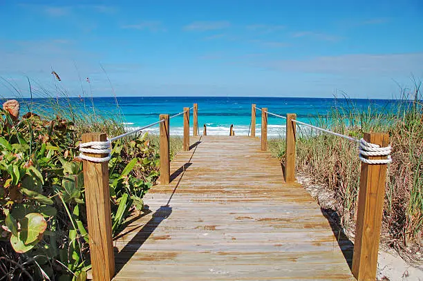 A weathered board walk leads to the Caribbean Sea on Stocking Island in the Bahamas.