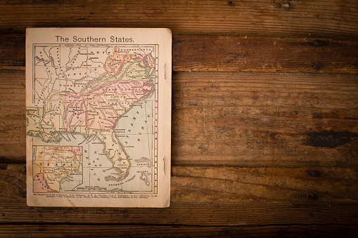 Color image of an old map of the Southern (United) States, from the 1800's, sitting on wood background, with copy space.