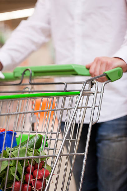 istock Young man with pushcart in supermarket 471422119