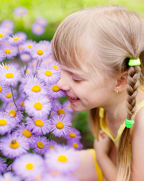 istock girl smelling flower 471422617