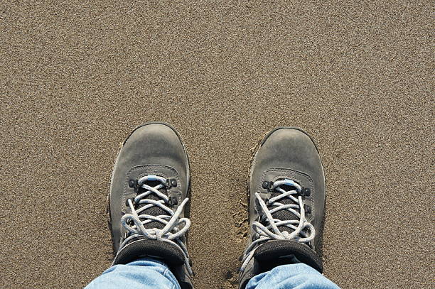 istock Shoes at water's edge on beach 471422958