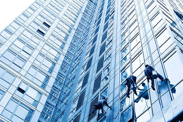 Cleaners are  cleaning building glass