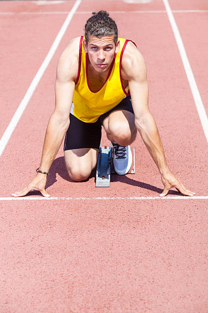 maschio atleta pronto a iniziare la corsa - rivalry starting block track and field athlete track and field foto e immagini stock