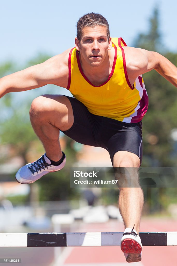 Maschio atleta durante la gara di ostacolo - Foto stock royalty-free di Correre