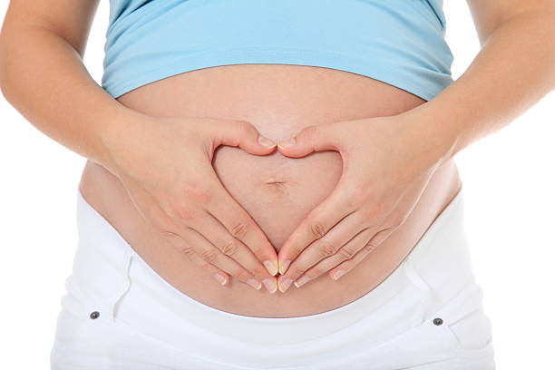 istock Woman forming heart on her baby bump 471428263