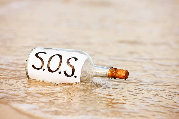 sos メッセージを洗ってボトルに時 - message in a bottle beached bottle desert island ストックフォトと画像