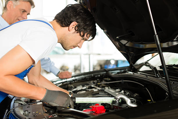 istock Mature man and mechanic look at car engine 471429877