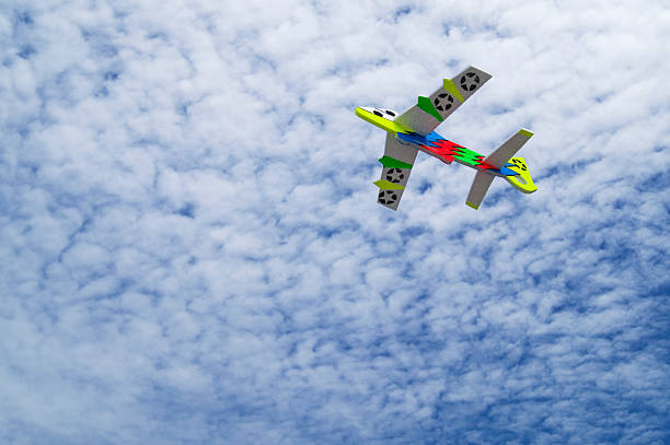istock colorful toy plane against blue sky. 471430895