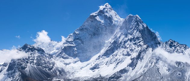 Ama Dablam is a mountain in the Himalaya range of eastern Nepal. The main peak is 6,812  metres (22,349 ft), the lower western peak is 5,563 metres (18,251 ft). Ama Dablam means  \