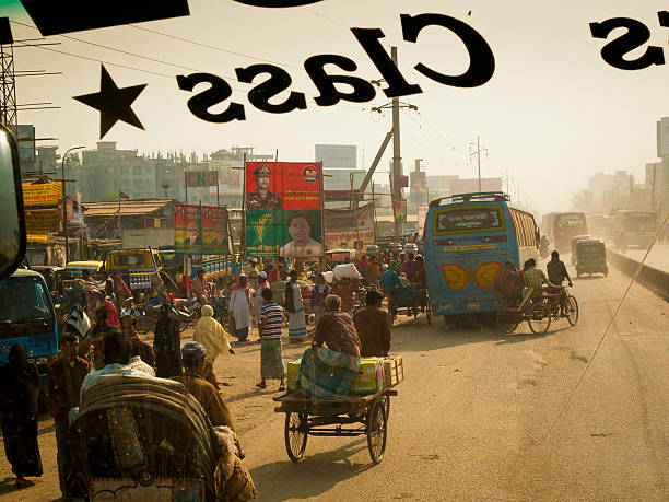 Dhaka, Bangladesh - February 2, 2012: Chaotic street full of rickshaw and people selling goods in front of busy bazaar, with obsolete residential buildings in Dhaka city in Bangladesh. 