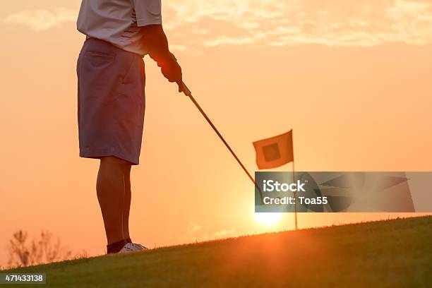 Man Putting Golf Ball Against Sunset Stock Photo - Download Image Now - 2015, Active Lifestyle, Activity