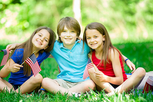 istock Children hold American flags outdoors, summer. Memorial Day, July 4th. 471433346