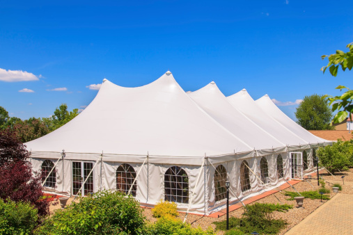 Beautiful outdoor event tent with patio, landscaping and blue sky in the background