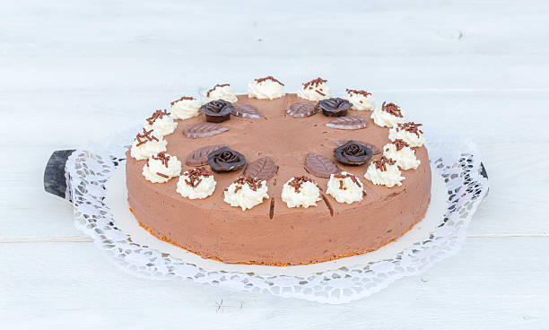 istock Chocolate cream cake on white wood with cake lace 471436036