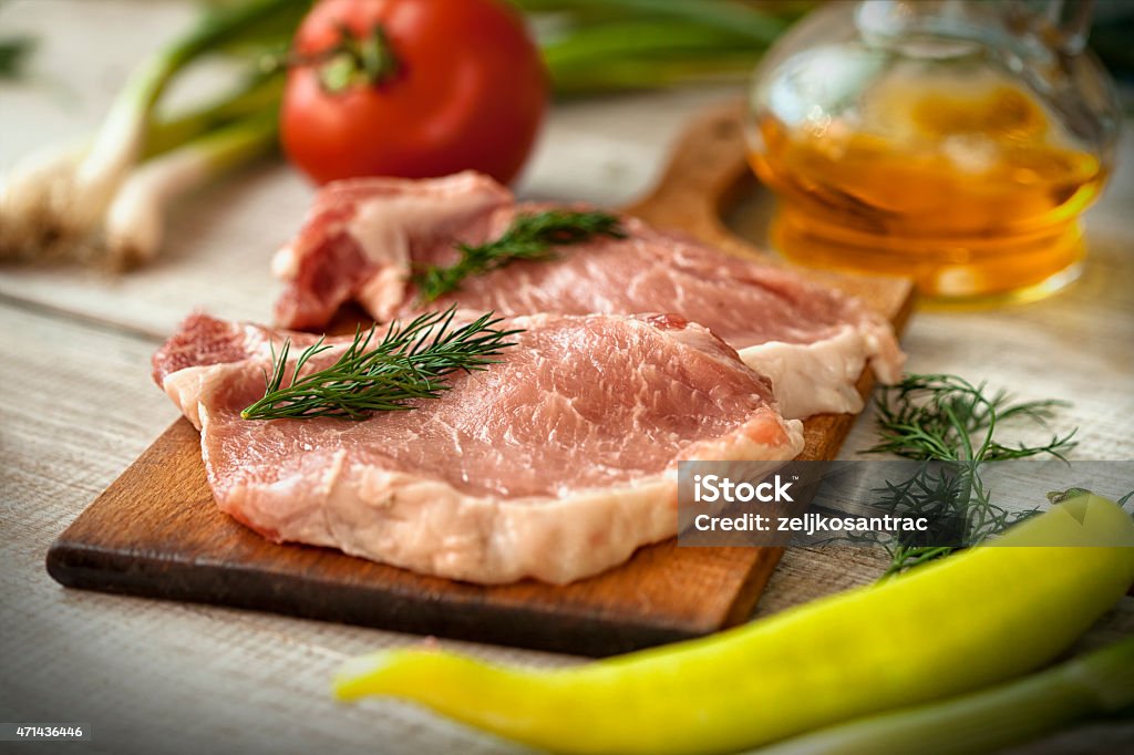 Raw Meat on the Chopping Board with Various Vegetables Sliced medium rare  steak , with  fresh vegatbles on cutting board on wooden background  2015 Stock Photo