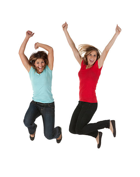 Portrait of cheerful teenage girls jumping together in summer city park. Concept of happy adolescence