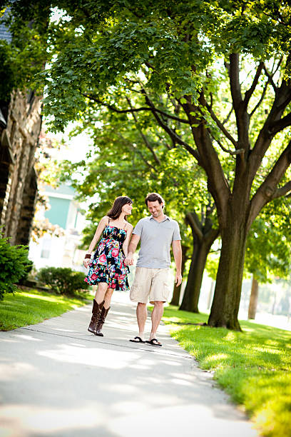 istock Happy, Young Couple Walking Along Sidewalk Together Outside 471436603