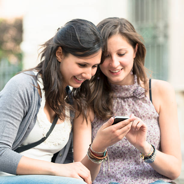 istock beautiful girls text messaging with own smartphone 471436629