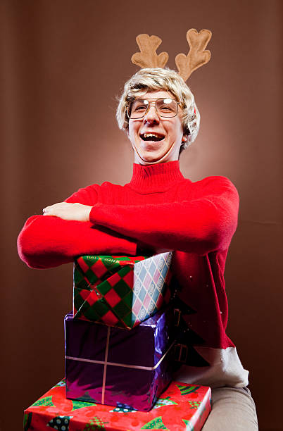 Excited Christmas Boy Portrait Portrait of a nerdy Christmas boy with stack of gifts. vintage nerd with reindeer sweater stock pictures, royalty-free photos & images