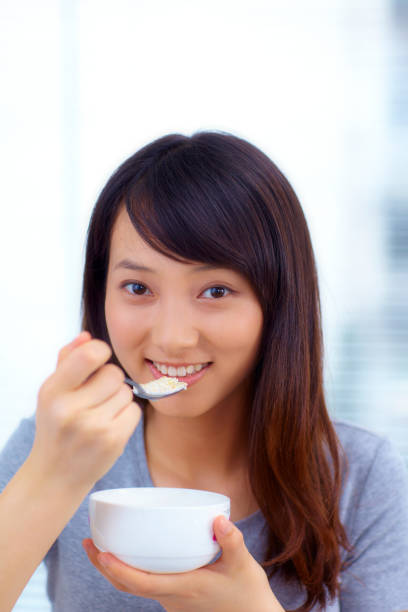 istock pretty young woman eating breakfast indoor 471438295