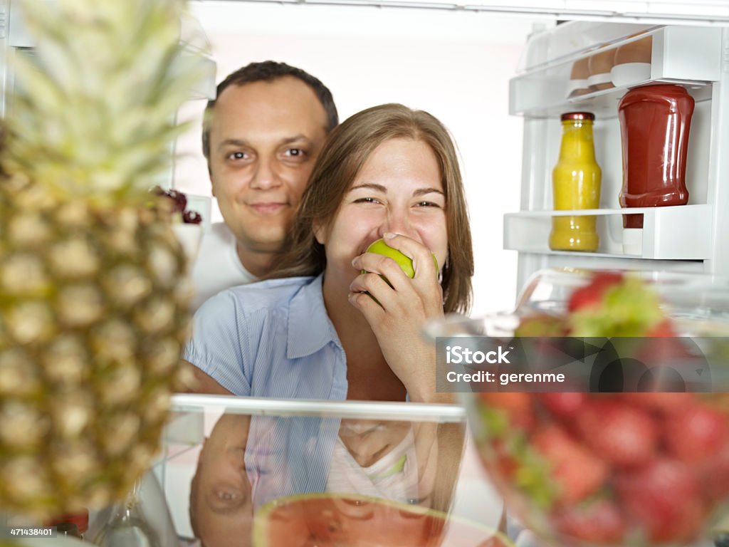 Casal olhando para a câmera com geladeira - Foto de stock de Abacaxi royalty-free