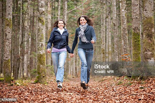 Photo libre de droit de Femmes Amis Courir À Travers Feuilles Dautomne banque d'images et plus d'images libres de droit de Courir