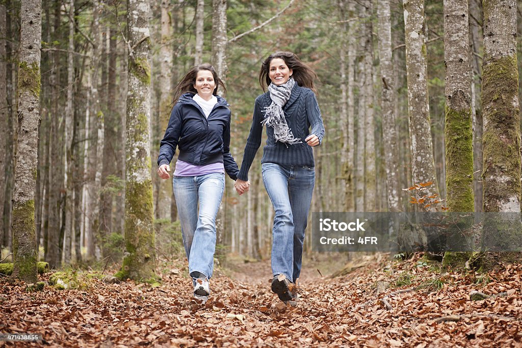女性の友人を走る秋の葉（XXXL ) - ジーンズのロイヤリティフリーストックフォト