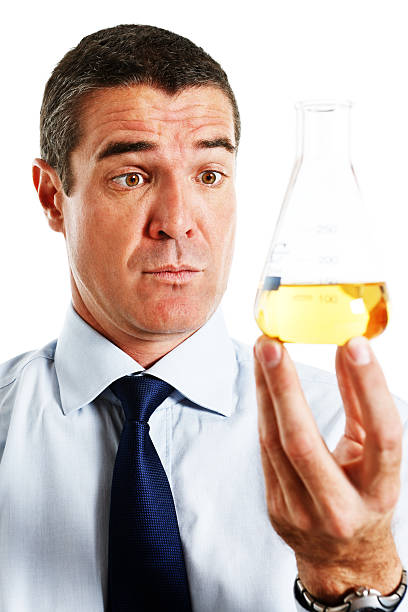 istock Concerned businessman holds flask containing yellow fluid, possibly urine 471439749