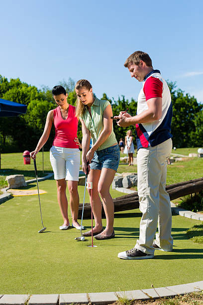 istock People playing miniature golf outdoors 471439967