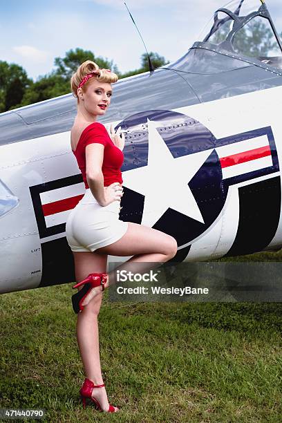 Pinup Girl In Red Shirt Leaning Against Wwii Airplane Stock Photo - Download Image Now