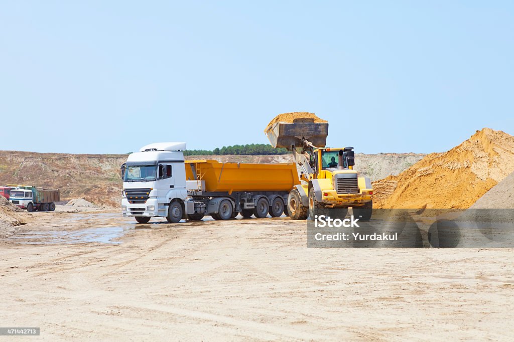 machines working at sand mine a construction scoop loading a dump truck with sand Blue Stock Photo