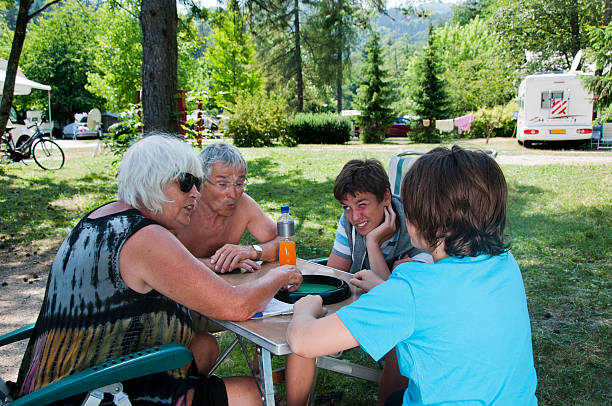 famille jouant le jeu de dés sur camp 4 - motor home mobile home camping senior adult photos et images de collection