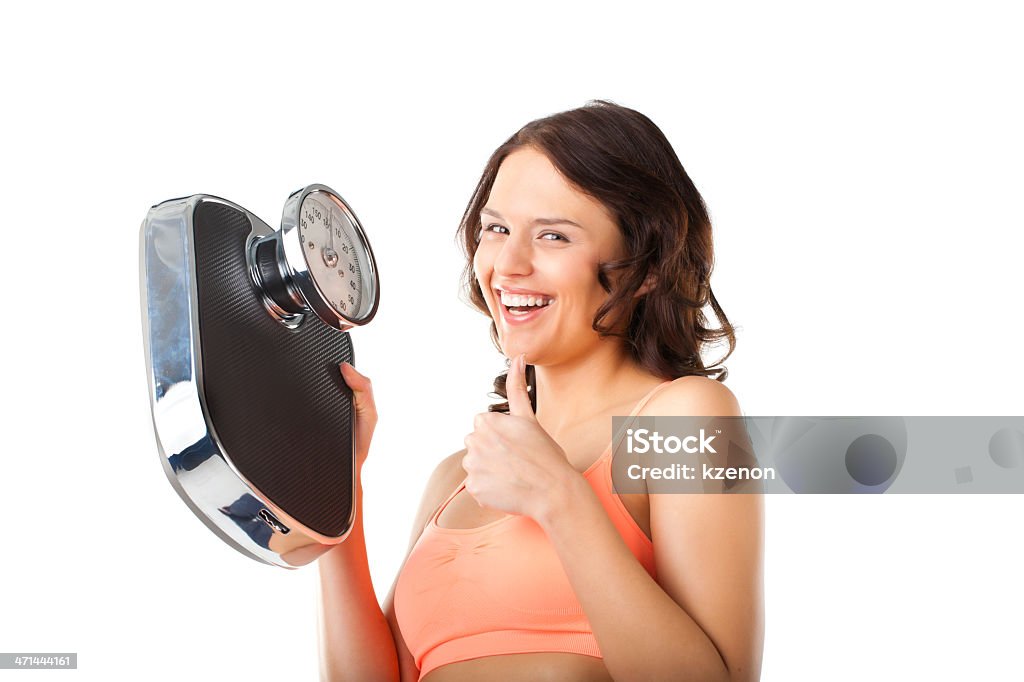 Young woman with measuring scale Diet and weight, young woman with a scale, she is happy about the success Adult Stock Photo