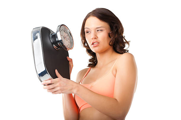 giovane donna con scale di misurazione - emaciated weight scale dieting overweight foto e immagini stock