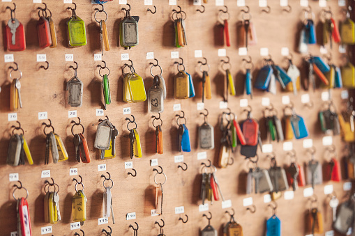 A large group of keys hanging on a rack. Some are missing and