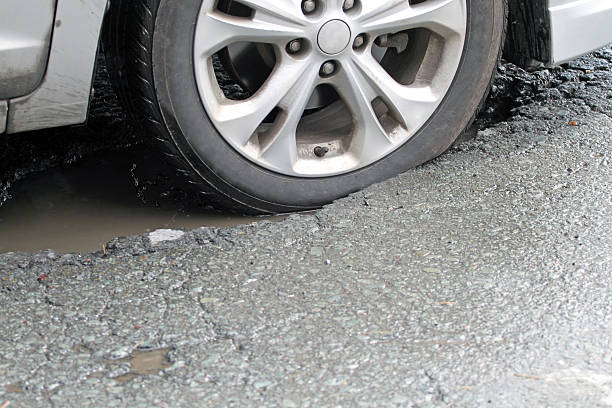 istock Vehicle Tire Hitting A Pothole On A City Street 471444552