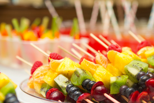 Fruit skewers on a serving platter at a birthday party. Very narrow depth of field.